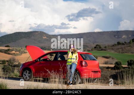 Frau, die auf dem Land eine Panne hat und telefoniert Stockfoto