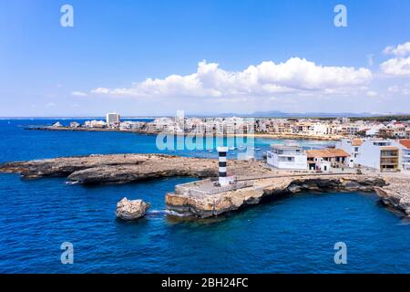 Spanien, Balearen, Colonia de Sant Jordi, Küstenleuchtturm mit Stadt im Hintergrund Stockfoto