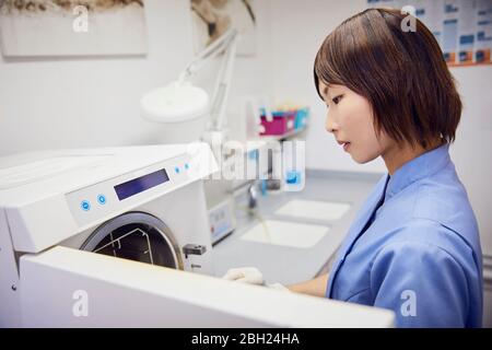 Zahnärztlicher Assistent in der Praxis Sterilisationsgeräte Stockfoto