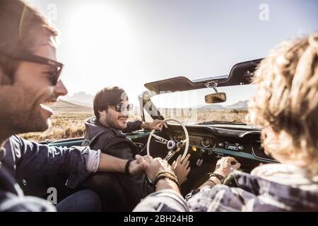 Glückliche Freunde im Cabrio auf einer Autoreise Stockfoto