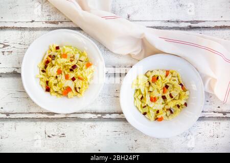 Zwei Teller Wintersalat mit Chinakohl, Äpfeln und Karotten Stockfoto