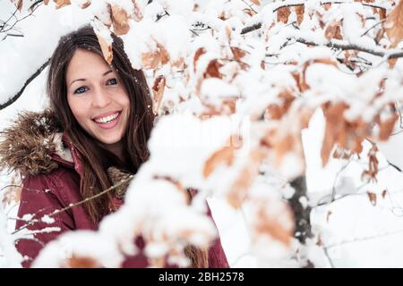 Portrait einer glücklichen jungen Frau, die im Winter die Natur genießt Stockfoto