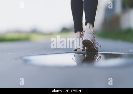 Joggingdaille, Spiegelung von Laufschuhen in einer Pfütze Stockfoto