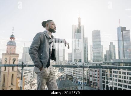 Stilvoller Mann auf der Aussichtsterrasse mit Blick auf skycraper, Frankfurt, Deutschland Stockfoto