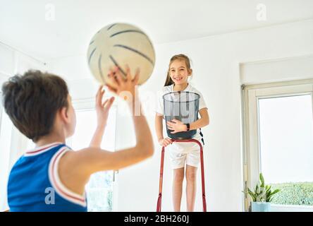 Junge und Mädchen spielen Basketball zu Hause Stockfoto