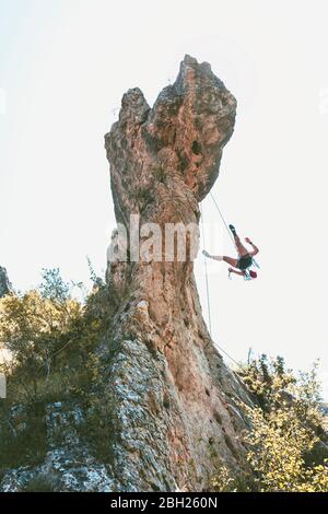 Junge Frau klettert auf die Felsennadel in Kantabrien, Spanien Stockfoto