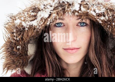 Porträt einer jungen Frau mit blauen Augen im Winter Stockfoto