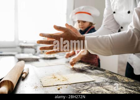 Vater mit Tochter bereitet Teig für hausgemachte glutenfreie Pasta in der Küche zu Hause Stockfoto