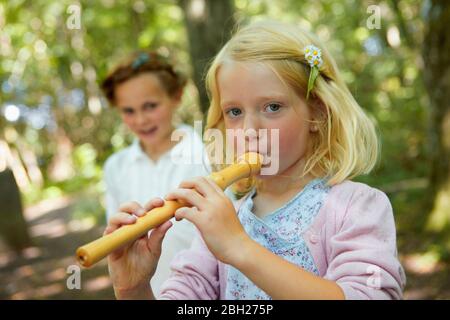 Portrait von Mädchen spielen Blockflöte im Wald Stockfoto