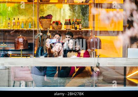 Freunde treffen sich in einer trendigen Bar, nehmen Smartphone Selfies Stockfoto