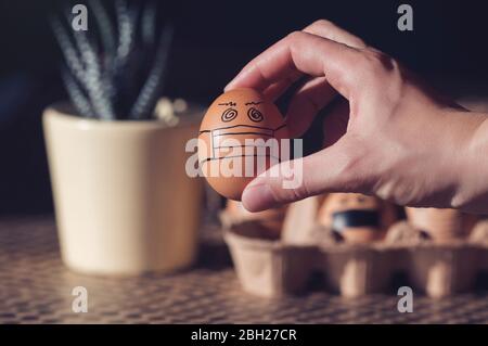 Ostereier mit Gesichtsmasken in einem Karton Stockfoto