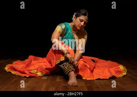 Kathak Tänzerin, die ghungroo in ihre Knöchel bindet. Stockfoto