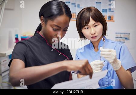 Zahnarzt und denal-Assistentin im Gespräch in der Praxis Stockfoto