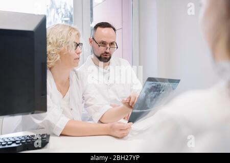 Zahnärzte disusing Röntgenergebnisse vor dem Patienten Stockfoto