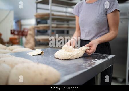 Nahaufnahme einer Frau, die in der Bäckerei Brot zubereitet Stockfoto