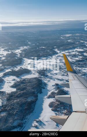 Finnland, Flugzeugflügel, der im Winter über bewaldete Landschaft fliegt Stockfoto