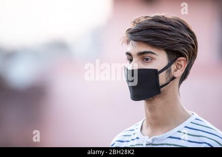 Asiatische Teenager Junge mit Maske des Gesichts während Lock down von Covid-19 oder Coronavirus-Infektion Stockfoto