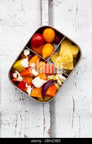 Lunchbox mit herbstlich gebackenem Gemüse, Feta-Käse und herzförmiger Polenta Stockfoto