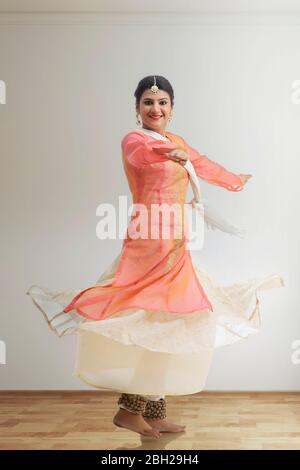 Schöne Kathak Tänzerin kreist und lächelt. Stockfoto