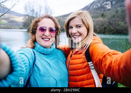 Porträt von zwei glücklichen Frauen, die Selfie, Valdemurio Reservoir, Asturien, Spanien Stockfoto