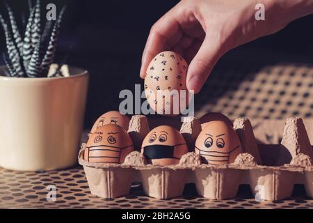 Ostereier mit Gesichtsmasken in einem Karton Stockfoto