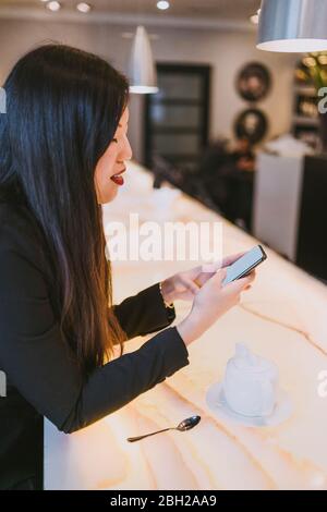 Elegante junge Frau mit Smartphone in einem Café Stockfoto