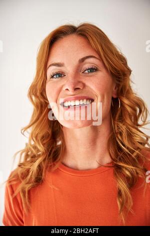Porträt einer lächelnden rothaarigen Frau, die die Kamera anschaut Stockfoto