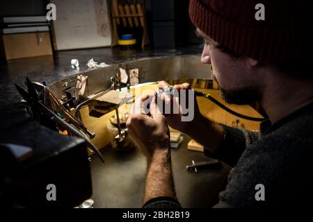 Goldschmied arbeitet an Ring in seiner Werkstatt Stockfoto