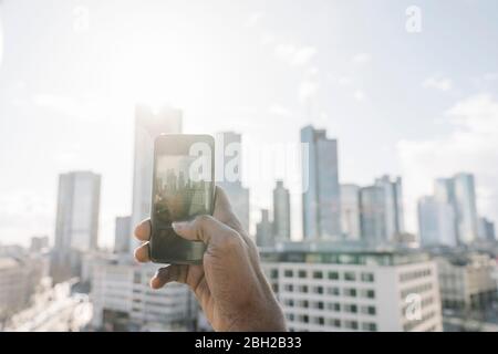Nahaufnahme eines Mannes auf der Aussichtsterrasse, der ein Handy-Foto macht, Frankfurt, Deutschland Stockfoto
