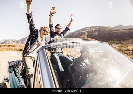 Glückliche Freunde im Cabrio auf einer Autoreise Stockfoto