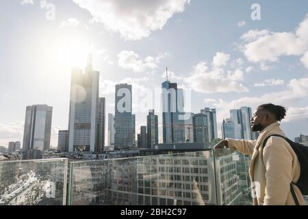 Stilvoller Mann auf der Aussichtsterrasse mit Blick auf skycraper, Frankfurt, Deutschland Stockfoto