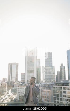 Stilvoller Mann am Telefon auf Aussichtsterrasse mit skycraper-Blick, Frankfurt, Deutschland Stockfoto