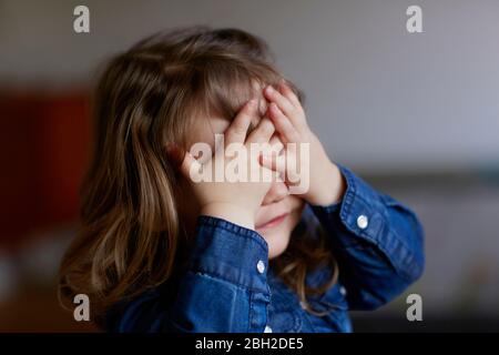 Portrait von Kleinkind Mädchen, die Augen mit ihren Händen Stockfoto