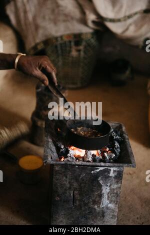 Zugeschnittenes Bild einer Frau, die während der traditionellen Zeremonie Kaffee zubereitet, Äthiopien, Central Tigray, Mugulat Stockfoto