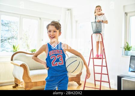 Glücklich Junge und Mädchen spielen Basketball im Wohnzimmer Stockfoto