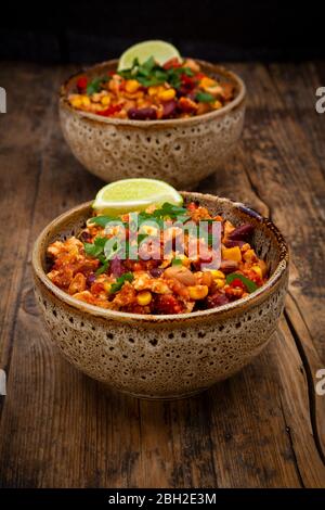 Zwei Schüsseln vegetarische Chili mit Tofu, Mais, Nieren und Pinto Bohnen, Koriander und Limette Stockfoto