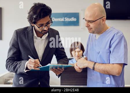 Patient und Zahnarzt an der Rezeption einer Zahnarztpraxis Stockfoto