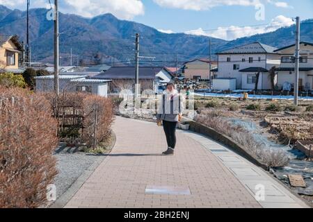 Eine Frau im Pullover, die im Dorf Yamanashi, Japan, auf der Straße steht, 10. Februar 2020 Stockfoto