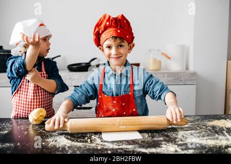 Bruder und Schwester bereiten Teig in der Küche zu Hause Stockfoto