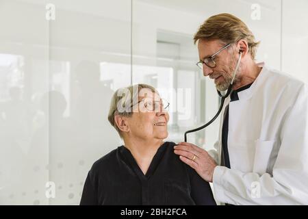 Arzt, der einen älteren Patienten in der medizinischen Praxis untersucht Stockfoto