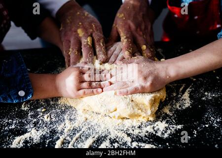 Nahaufnahme der Hände beim Zubereiten des Teiges in der Küche zu Hause Stockfoto