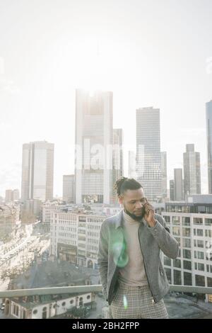 Stilvoller Mann am Telefon auf Aussichtsterrasse mit skycraper-Blick, Frankfurt, Deutschland Stockfoto