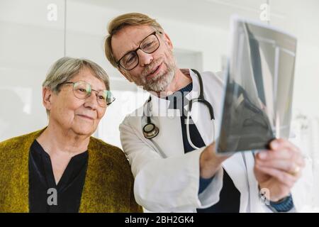 Arzt bespricht Röntgenbild mit dem älteren Patienten Stockfoto