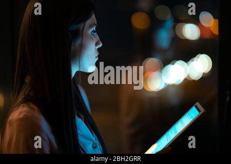 Nachdenkliche junge Frau mit digitalem Tablet im Büro Stockfoto