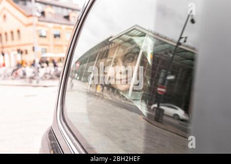 Frau im hinteren Teil eines Taxis, die aus dem Fenster schaute, London, Großbritannien Stockfoto