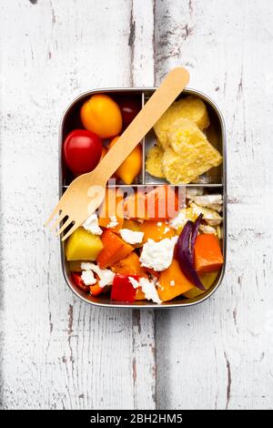 Lunchbox mit herbstlich gebackenem Gemüse, Feta-Käse und herzförmiger Polenta Stockfoto