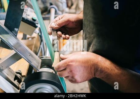 Handwerker, der in seiner Werkstatt am Messer arbeitet Stockfoto