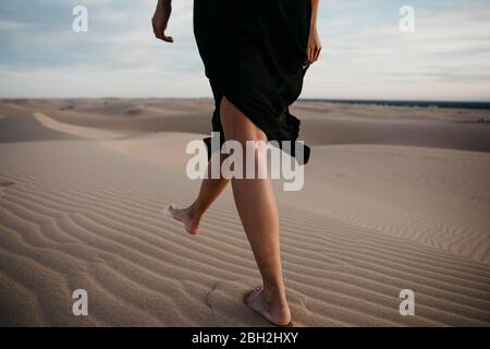 Crop-Ansicht von Frau, die barfuß auf Sanddüne, Algodones Dunes, Brawley, USA, läuft Stockfoto