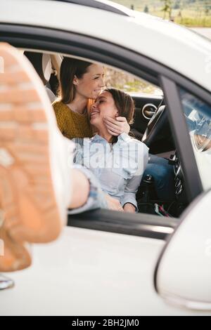 Zwei glückliche, liebevolle junge Frauen in einem Auto Stockfoto