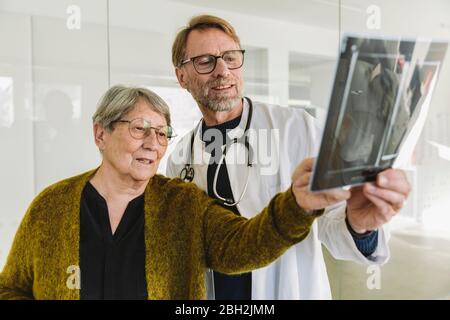 Arzt bespricht Röntgenbild mit dem älteren Patienten Stockfoto